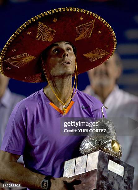 Rafael Nadal of Spain wears a traditional Mexican mariachi hat while holding the winning trophy after defeating his compatriot David Ferrer at the...