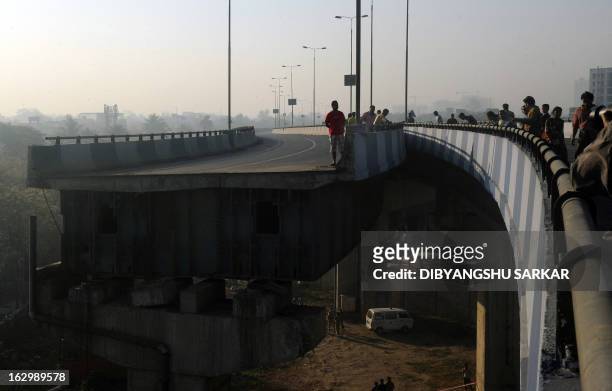 Indian onlookers stand near the collapsed portion of the flyover in Kolkata on March 3, 2013. A huge portion of a flyover on the eastern side of the...
