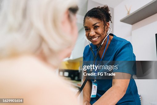 Nurse taking blood pressure of a senior woman patient at home Nurse taking blood pressure of a senior woman patient at home