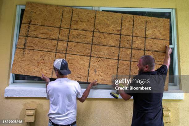 Residents place a wooden board to protect a house in St. Petersburg, Florida, US, on Monday, Aug. 28, 2023. Tropical Storm Idalia strengthened near...