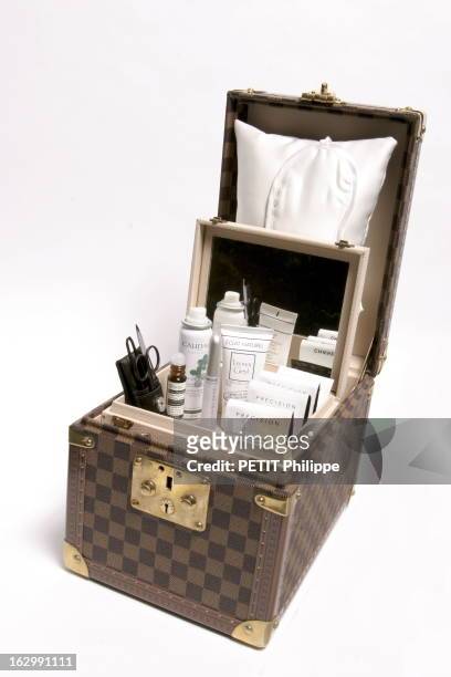 The Vanity. Dans un vanity en cuir à damiers Louis Vuitton, monodoses fluide éclat tenseur Chanel, un soin éclat du cheveu sec Leonor Greyl, un roll...