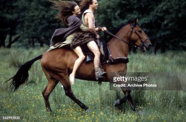 Catherine McCormack and Mel Gibson on horseback together in a scene from the film 'Braveheart', 1995.