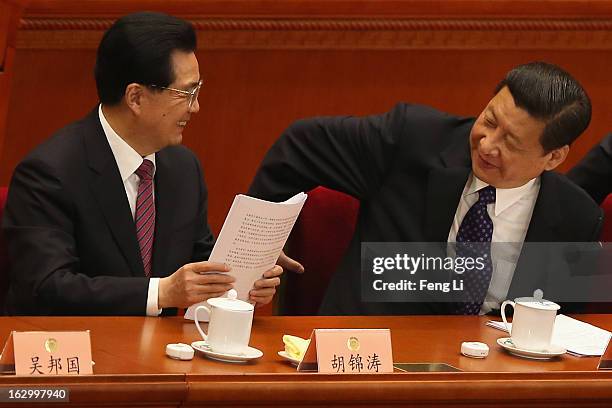 Communist Party chief Xi Jinping and Chinese President Hu Jintao look at each other as they leave after the opening session of the Chinese People's...