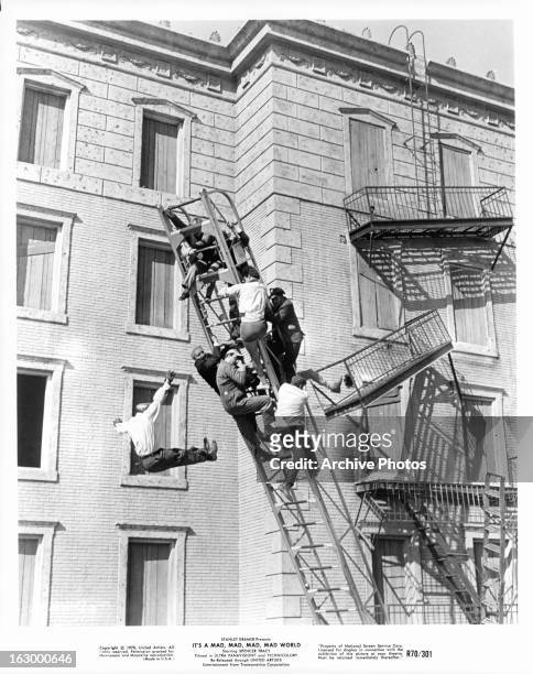 Several men climb a fire escape in a scene from the film 'It's A Mad Mad Mad Mad World', 1963.