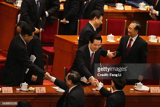 China's Communist Party Chief Xi Jinping shakes hands with China's Premier Wen Jiabao as China's President Hu Jintao shakes hands with delegate Ling...