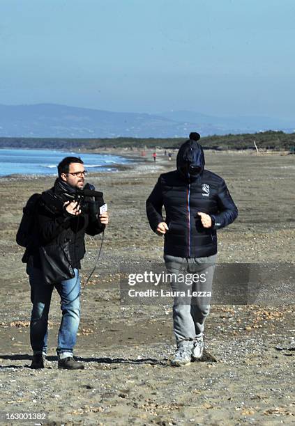 Italian comedian, blogger and political leader of the Five Stars Movement Beppe Grillo is questioned as he runs on the beach on March 3, 2013 in...