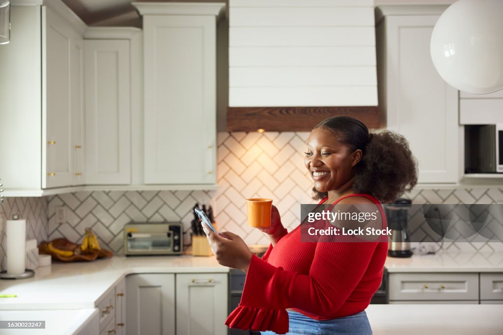 Young woman enjoys coffee in her kitchen