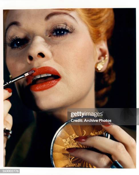 Lucille Ball paints her lips in a scene from the film 'Lured', 1947.