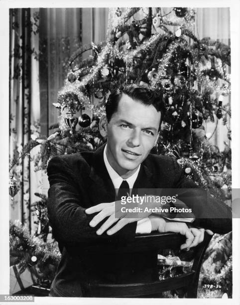 Frank Sinatra sits in front of a Christmas tree in a scene from the film 'Young At Heart', 1954.