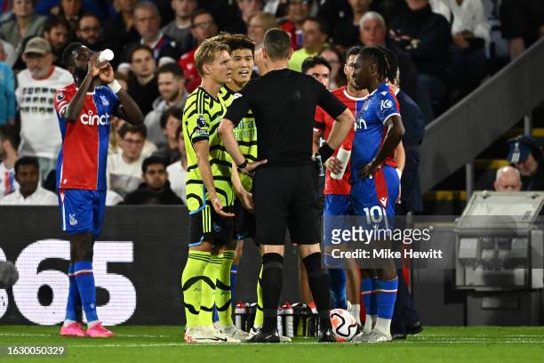 Takehiro Tomiyasu of Arsenal talks to Match Referee David Coote after being sent off for a second yellow card during the Premier League match between...