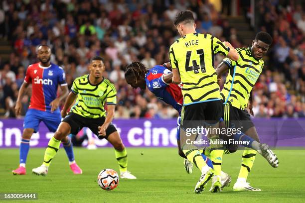 Eberechi Eze of Crystal Palace is challenged by Declan Rice and Thomas Partey of Arsenal during the Premier League match between Crystal Palace and...