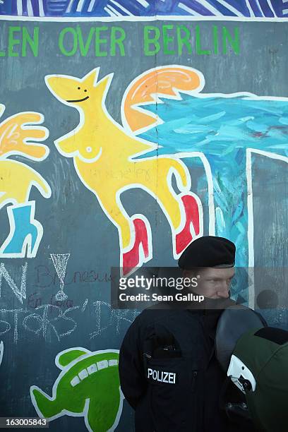 Police in riot gear stand guard at a section of the East Side Gallery, which is the longest still-standing portion of the former Berlin Wall, that is...