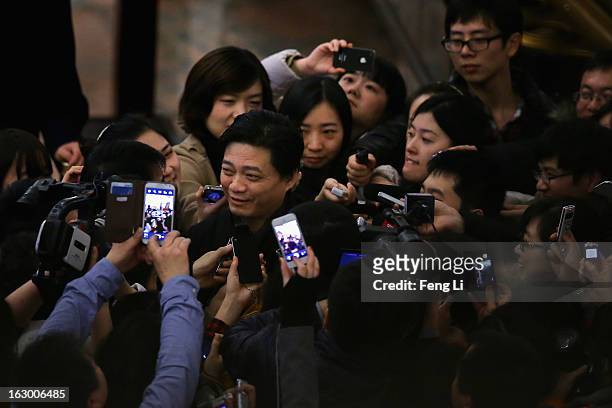 Cui Yongyuan , Chinese famous TV host, walks through a swarm of journalists after attending the opening session of the Chinese People's Political...