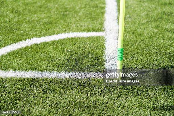 a white flagpole is buried inside the paint signed corner of a green soccer field. a flagpole is buried inside the grass of a soccer field. - corner kick stock pictures, royalty-free photos & images