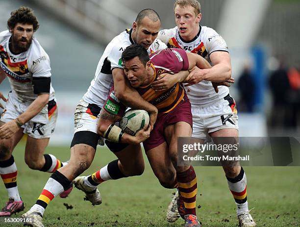 Jason Chan of Huddersfield tackled by Keith Lulia and Tom Olbison of Bradford during the Super League match between Huddersfield Giants and Bradford...