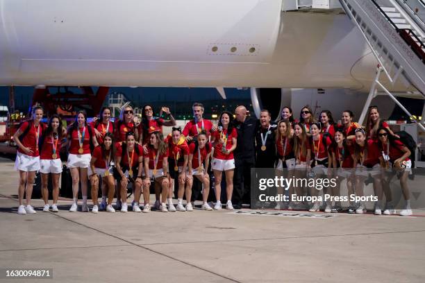 Spain women's national football player Ivana Andres holds up the World Cup trophy next to Spain's manager Jorge Vilda and Spanish football federation...