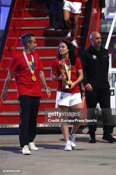 Spain women's national football player Ivana Andres holds up the World Cup trophy next to Spain's manager Jorge Vilda and Spanish football federation...