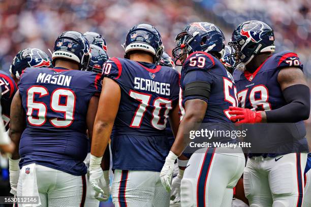 Shaq Mason, Juice Scruggs, Kenyon Green and Laremy Tunsil of the Houston Texans in the huddle during the preseason game against the Miami Dolphins at...