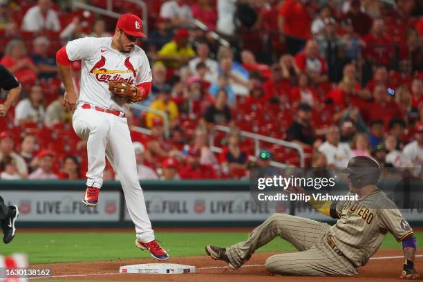 Nolan Arenado of the St. Louis Cardinals beats Manny Machado of the San Diego Padres to third base for an out in the seventh inning at Busch Stadium...