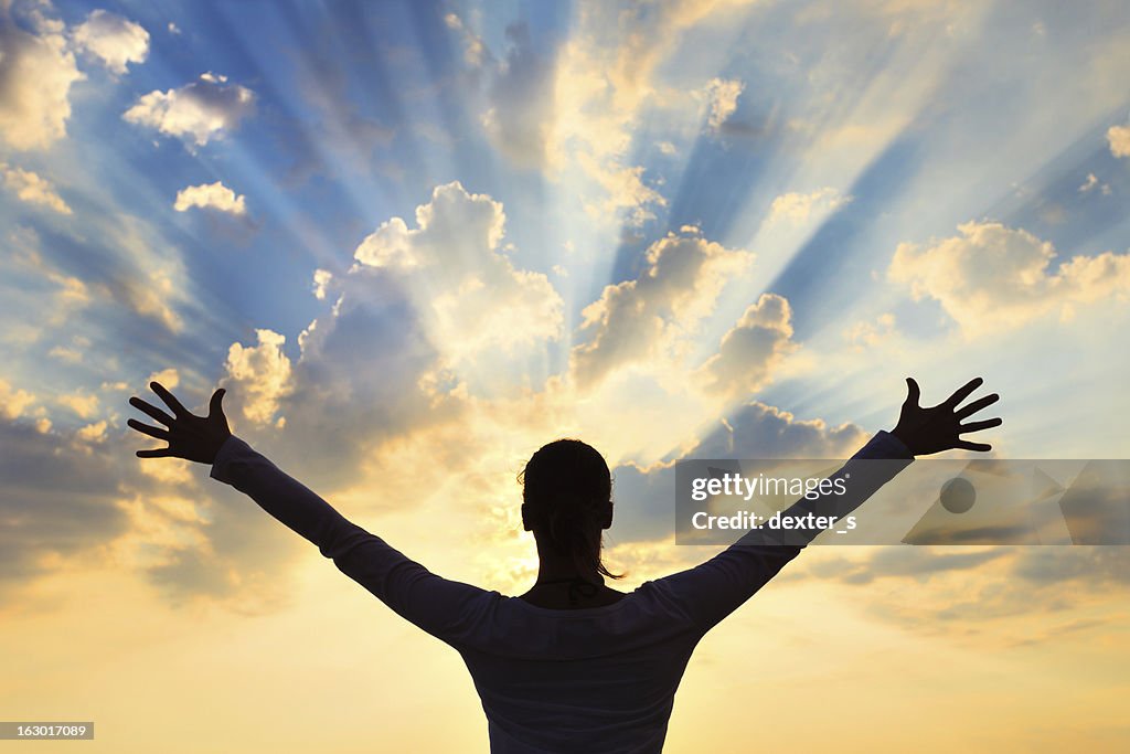 Woman Meditating At Sunset