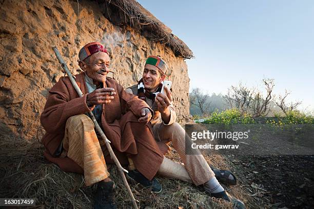 people of himachal pradesh: young man showing phone to grandfather - himachal pradesh stockfoto's en -beelden