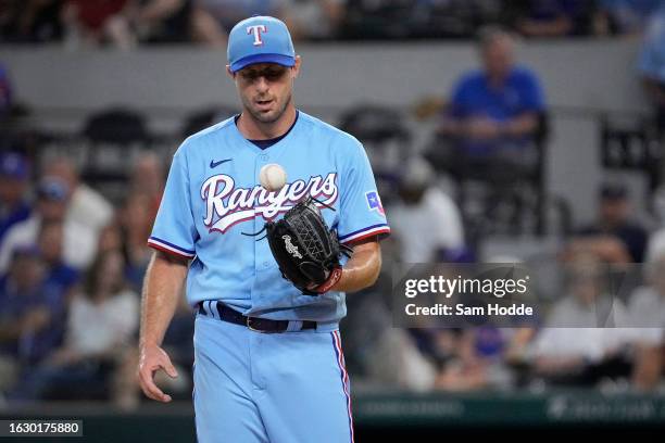 Max Scherzer of the Texas Rangers tosses a ball from his glove to his hand during the second inning against the Milwaukee Brewers at Globe Life Field...