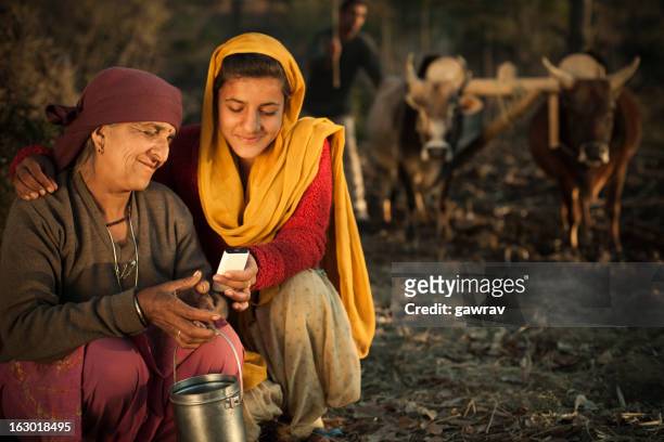 real people from rural india: peasant family using mobile phone - rural scene stock pictures, royalty-free photos & images