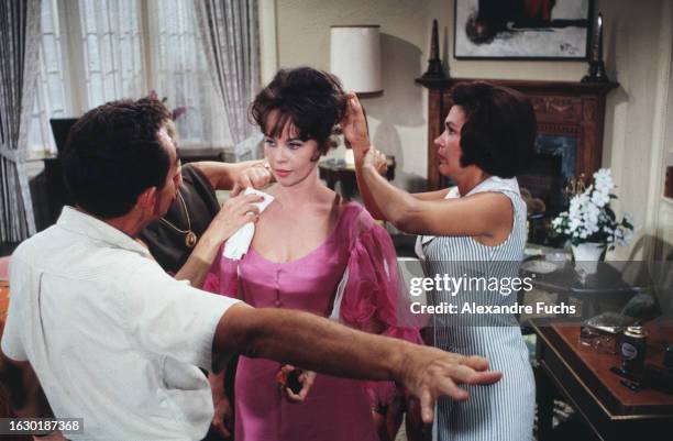 Actress Leslie Caron gets outfitted for the film 'Father Goose' while listening to director Ralph Nelson at Jamaica in 1963.