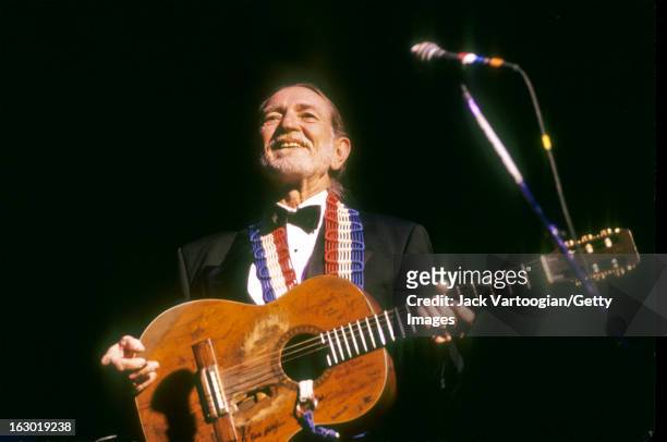 American country musician Willie Nelson, in formal attire, performs during a Valentine's Day concert at the Beacon Theater, New York, New York,...
