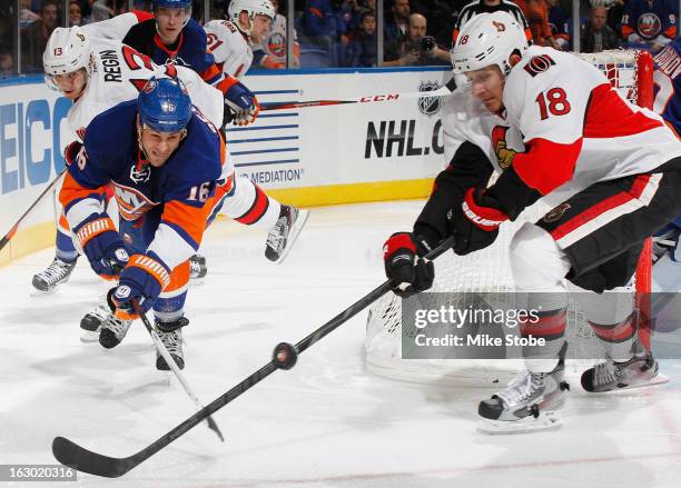 Marty Reasoner of the New York Islanders and Jim O'Brien of the Ottawa Senators lunge for the puck at Nassau Veterans Memorial Coliseum on March 3,...