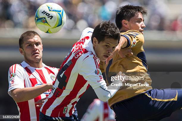 Efrain Velarde of Pumas struggles for the ball with Sergio Perez of Chivas during a match between Pumas and Chivas as part of Clausura 2013 Liga MX...