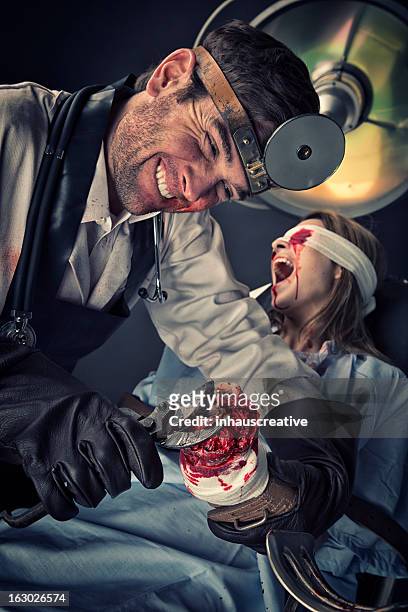 evil doctor cutting on missing hand of helpless female victim - female torture stock pictures, royalty-free photos & images