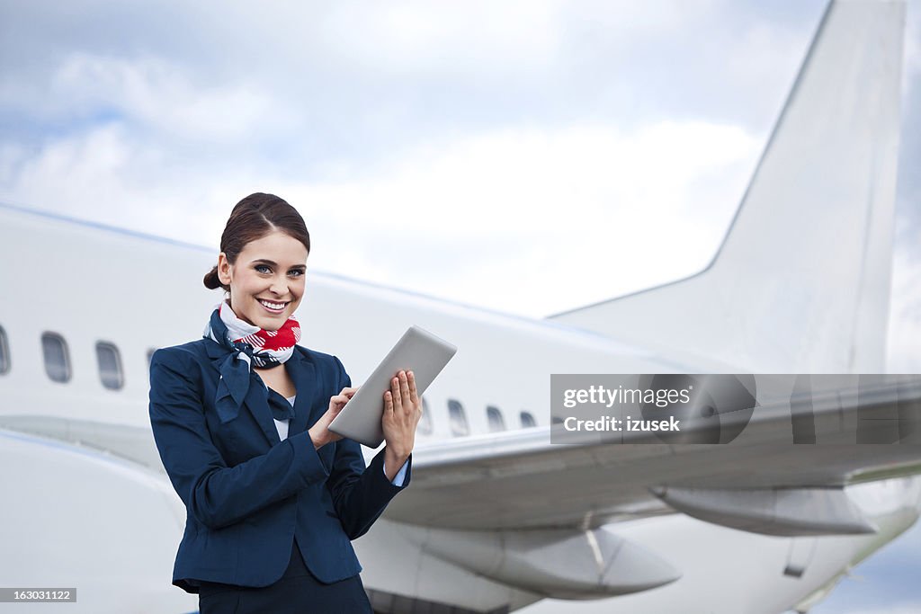 Beautiful air stewardess with digital tablet
