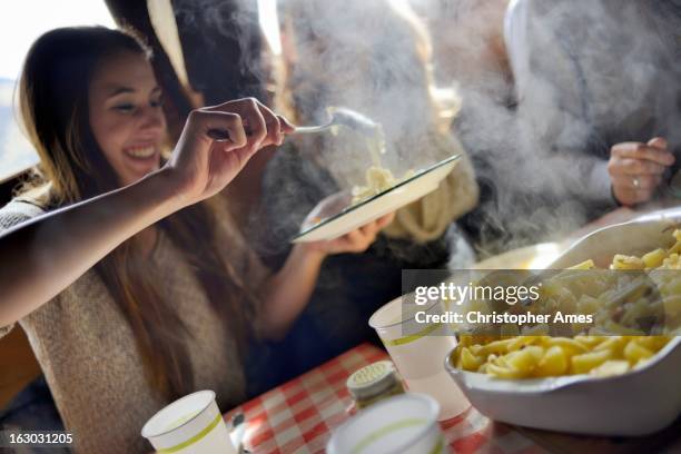 tourist enjoying traditional swiss meal alplermagronen - macaroni and cheese stockfoto's en -beelden