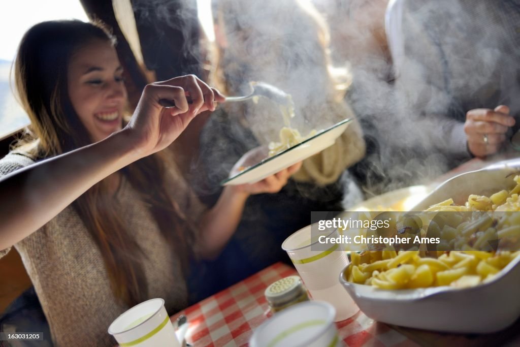 Tourist enjoying traditional Swiss meal Alplermagronen