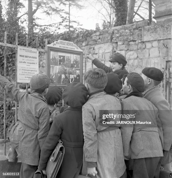 The Marie Besnard Case: The First Trial. Loudun, 25 février 1952 : un groupe d'enfants s'est réuni devant le panneau d'affichage en plein air du...