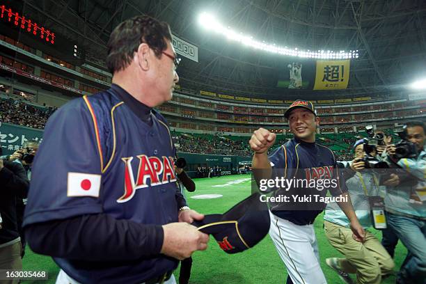 Shinnosuke Abe of Team Japan and Koji Yamamoto manager of Team Japan react to defeating Team Brazil in Pool A, Game 1 in the first round of the 2013...