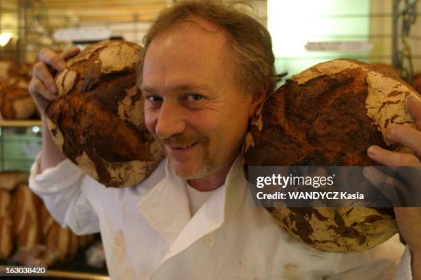 Bread And Bakers Craftsman. Attitude souriante de Basil KAMIR, le rocker du pain bio, posant avec deux miches dans sa boutique 'Le moulin de la...