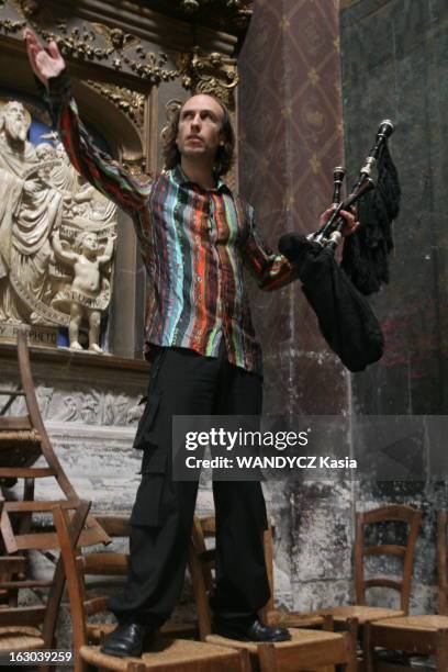 Carlos Nunez. Attitude du musicien celtique ibérique Carlos NUNEZ avec sa gaïta, la cornemuse galicienne, debout sur des chaises dans une chapelle..