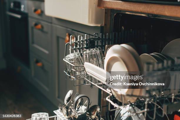 open dishwasher with clean utensils in it - dishwasher stock pictures, royalty-free photos & images