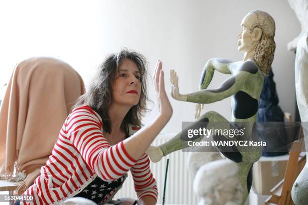 Rendezvous With Pascale Loisel. Attitude de Pascale LOISEL paume de la main contre celle d'une de ses sculptures modelée en pâte à bois dans son...