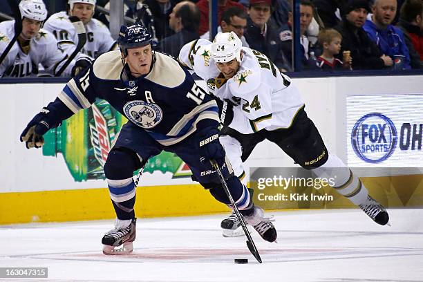 Derek Dorsett of the Columbus Blue Jackets skates the puck away from Eric Nystrom of the Dallas Stars on February 26, 2013 at Nationwide Arena in...