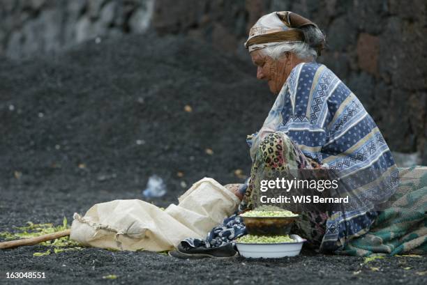 The Cape Verde Islands. Ile de Fogo : vieille femme assise par terre écossant des haricots dans le village de Portela au pied du volcan du Pico .