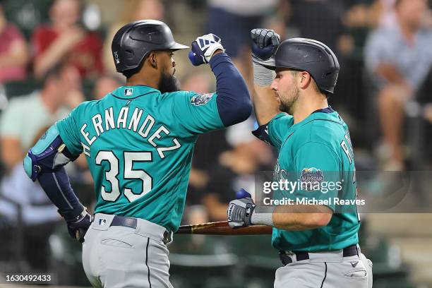 Cal Raleigh of the Seattle Mariners celebrates with Teoscar Hernandez after hitting a solo home run off Touki Toussaint of the Chicago White Sox...