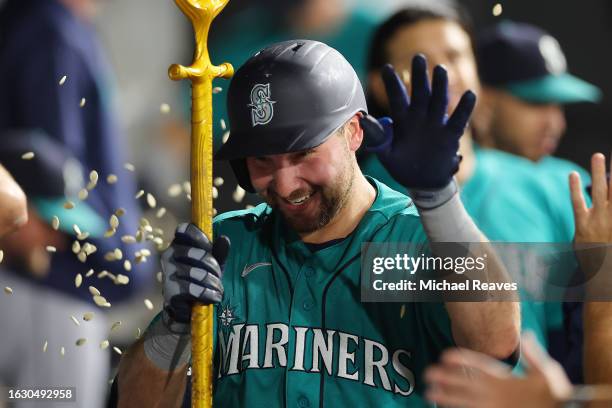 Cal Raleigh of the Seattle Mariners high fives teammates after hitting a solo home run off Touki Toussaint of the Chicago White Sox during the fifth...