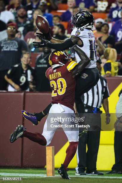 Jartavius Martin of the Washington Commanders breaks up and intercepts a pass intended for Tylan Wallace of the Baltimore Ravens during the first...