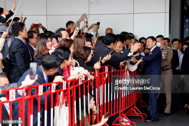 Former Thai prime minister Thaksin Shinawatra greets supporters as he arrives at Don Mueang International Airport on August 22, 2023 in Bangkok,...