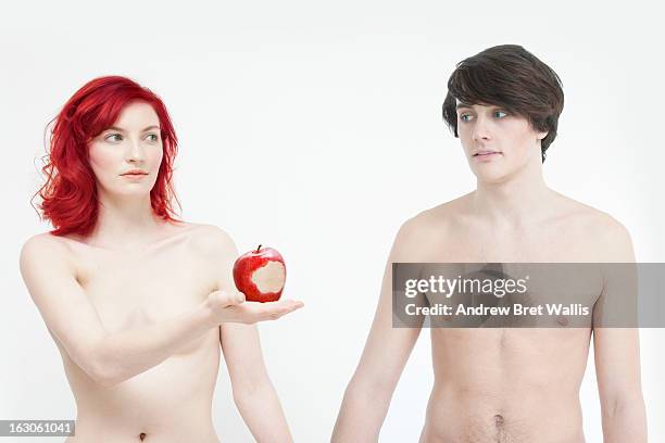 woman offers man red apple with a bite mark - adam stock pictures, royalty-free photos & images