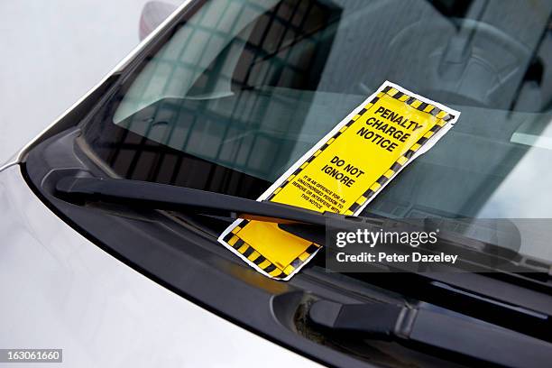 parking ticket on car windscreen - parabrisas fotografías e imágenes de stock