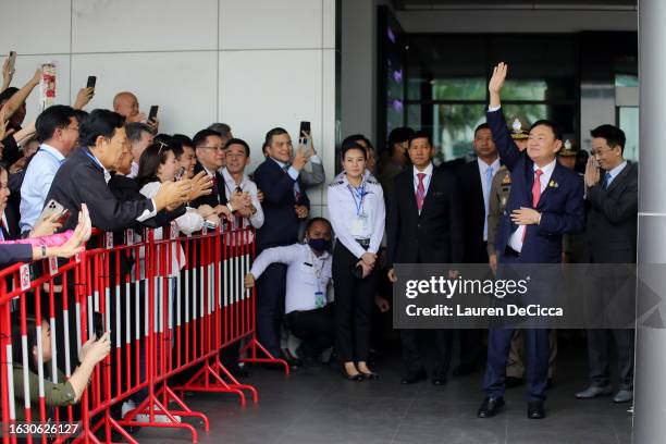 Former Thai prime minister Thaksin Shinawatra greets supporters as he arrives at Don Mueang International Airport on August 22, 2023 in Bangkok,...